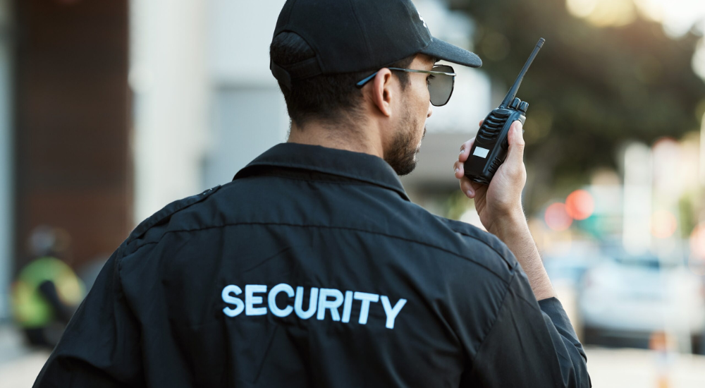 Male security guard officer communicating via walkie talkie on duty